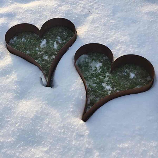 Liggende hjerte i jern til haven. Her lagt i sneen på græsplænen. Fås hos Luxuslife